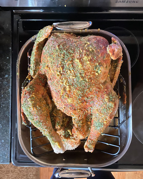 Turkey in All Clad roasting pan with rub on it