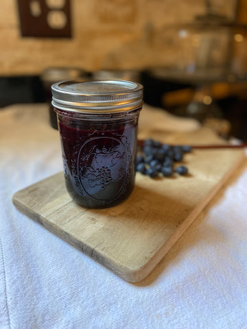 Blueberry jam on wooden board with blueberries