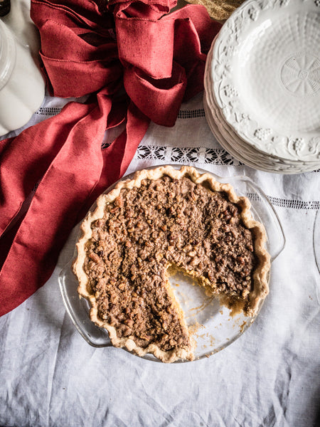 Flatlay of pumpkin pecan pie with slice out