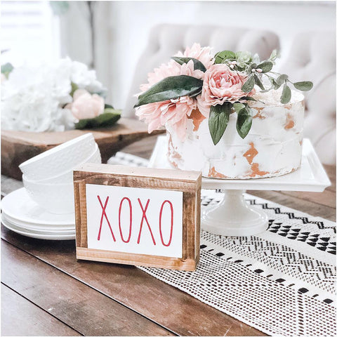 pink and white floral cake with xoxo sign