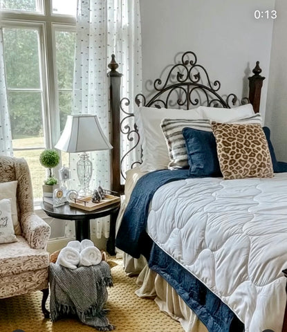 Bedroom view with blue and white bedding and leopard throw pillow