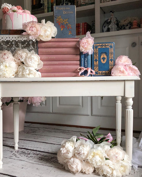 table with books flowers and faux cake