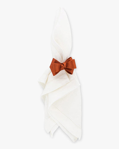 White napkin with orange bow napkin ring