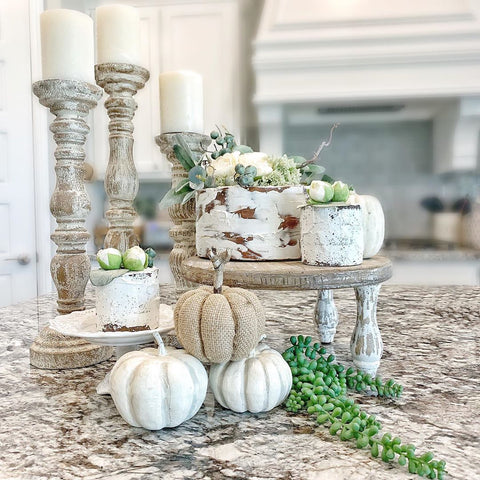 Faux cakes with greenery on wooden cake stands