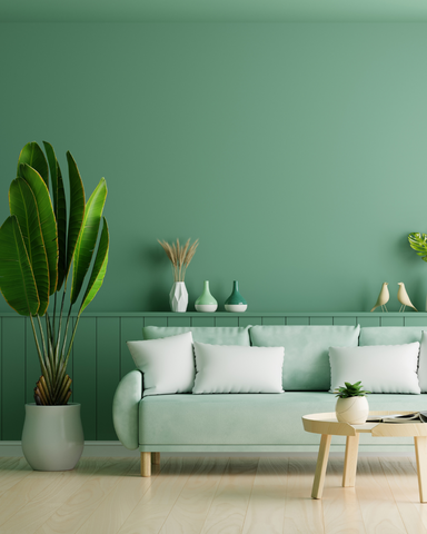 room with green walls, pastel green sofa and white pillows