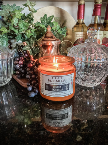 Colonial Candle pumpkin shortbread scent burning on counter with greenery behind