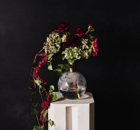 Red and green floral arrangement with red amaranth spilling over vase