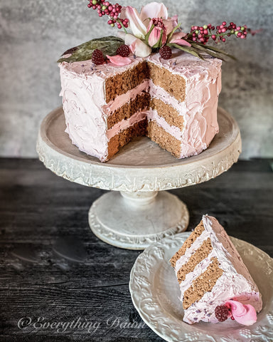 Pink faux cake with slice out set aside on white dessert plate