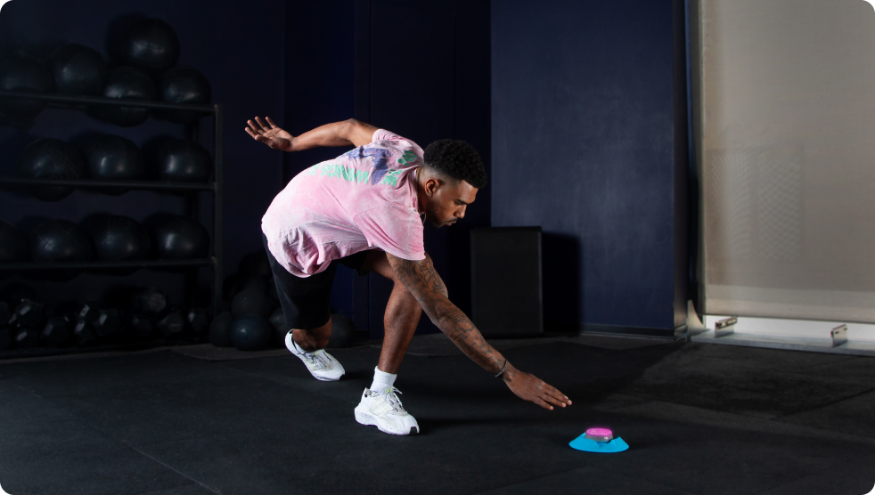 An athlete in a gym tapping out a Pod light