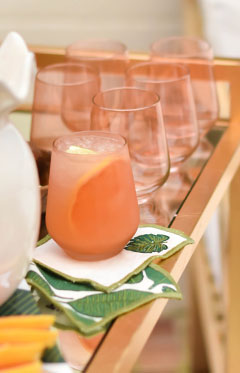 Paloma cocktail served on a gold bar cart with a palm cocktail napkin