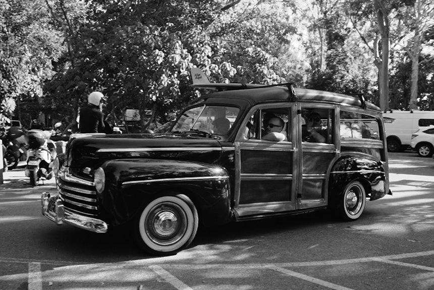 Old car with surfboard on roof