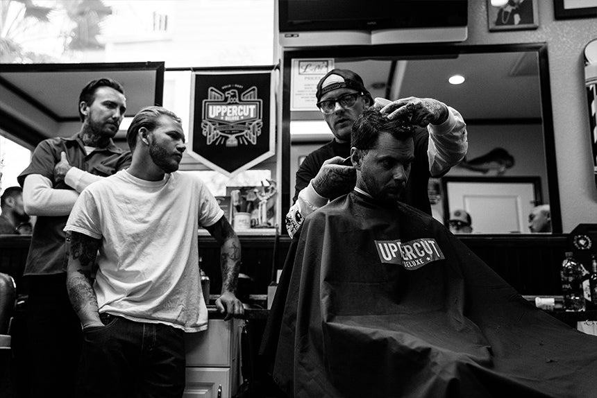 Barber cutting hair while others watch