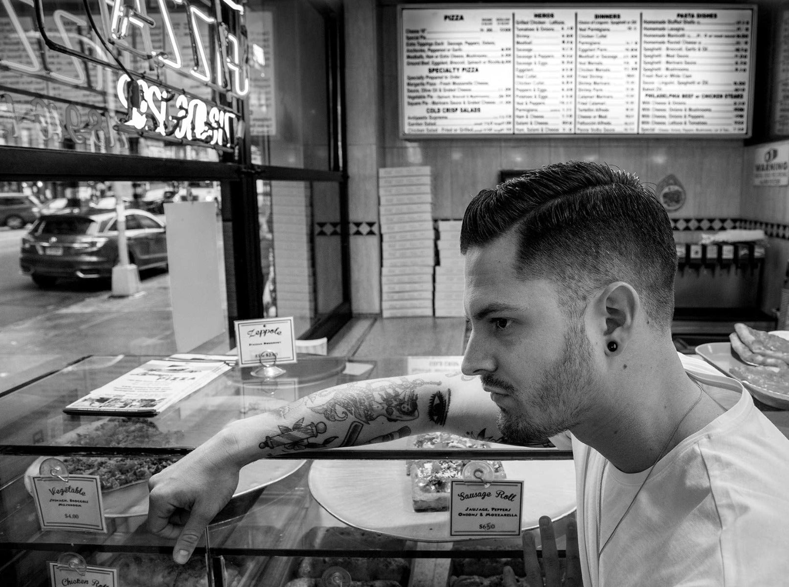 Man looking at pizzas