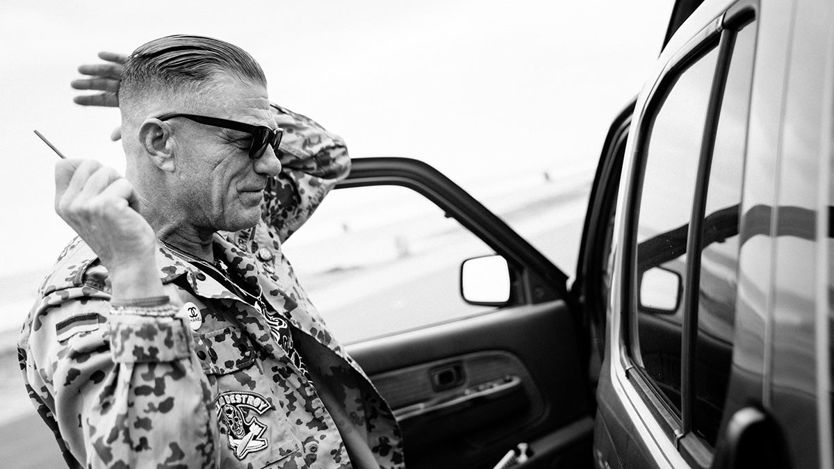 Man styling hair in car window