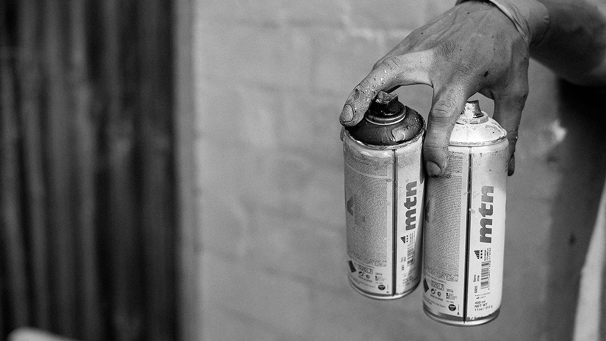 Hand holding spray paint cans
