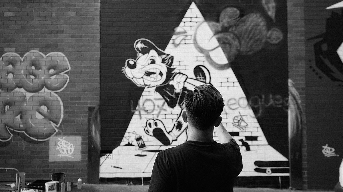 Man standing in front of grafitti wall