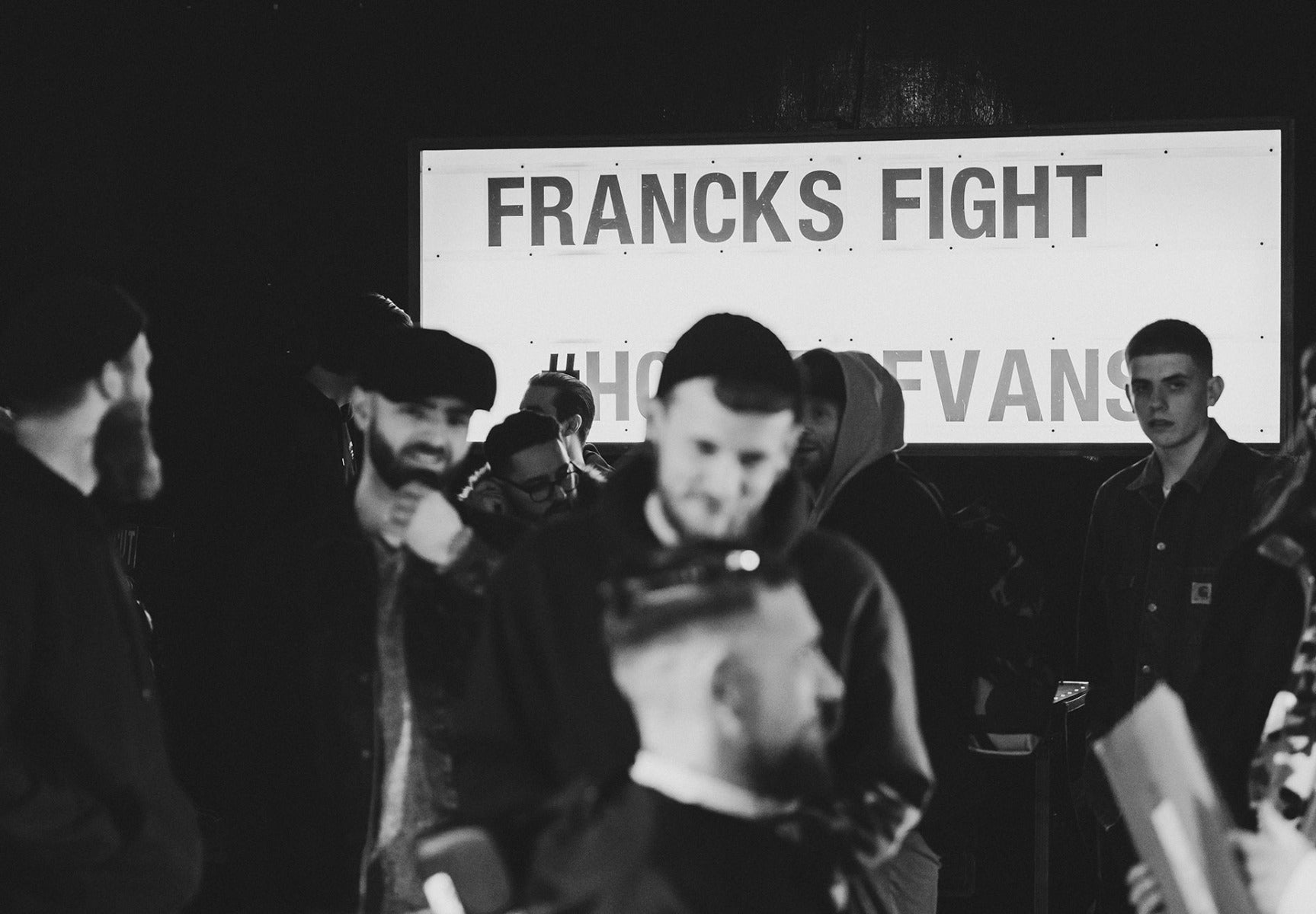 Group of people with Francks Fight sign in the background
