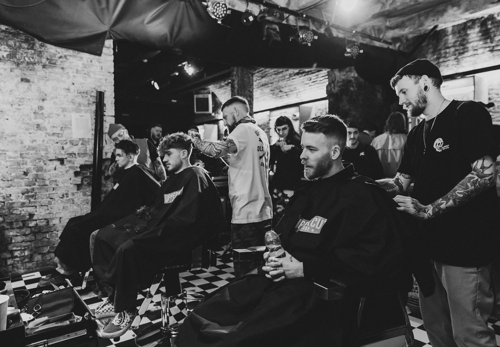 Men in barberchairs getting haircuts