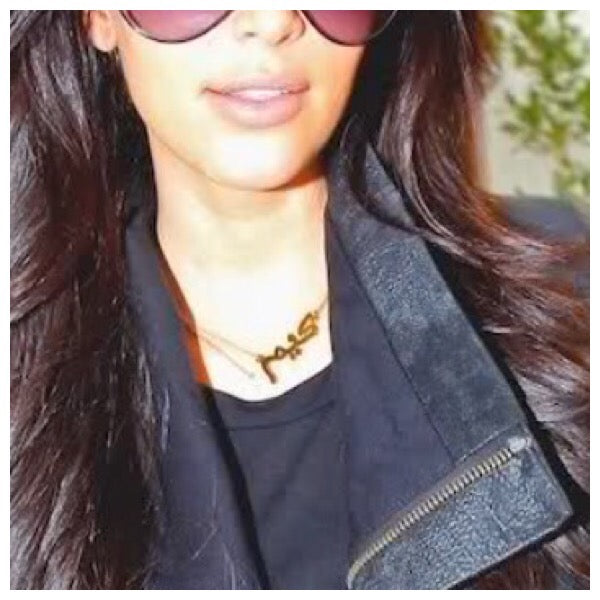 Kim kardashian portant un collier en or avec son nom en arabe