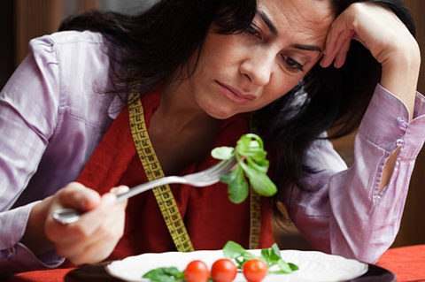 Unhappy lady eating salad