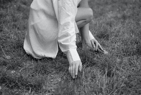 Akasha blends black and white figure kneeling on grass field