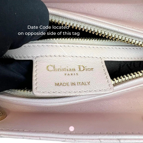 Image of a close-up of a Christian Dior label showing the location of the date code behind the logo tab