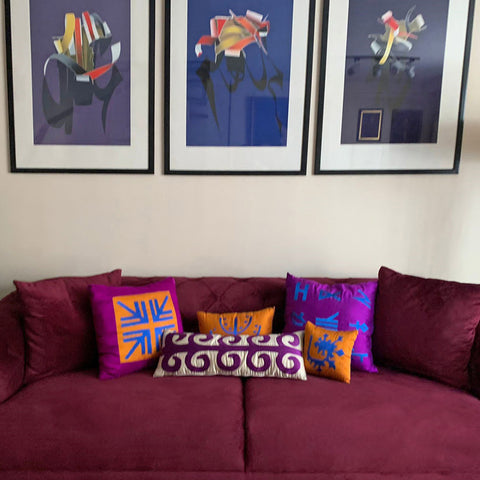Bordo kanepede turuncu ve mor yastiklar ve Burhan Dogancay tablolari_Orange and purple pillow case on a burgundy colored sofa and pictures above them