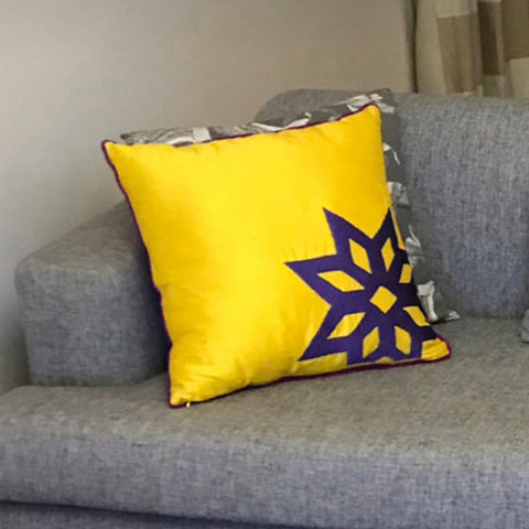 Gri kanepenin kosesinde yildiz desenli kanarya sarisi kare kirlent_Big yellow silk cushion with star motif at the corner of a grey sofa
