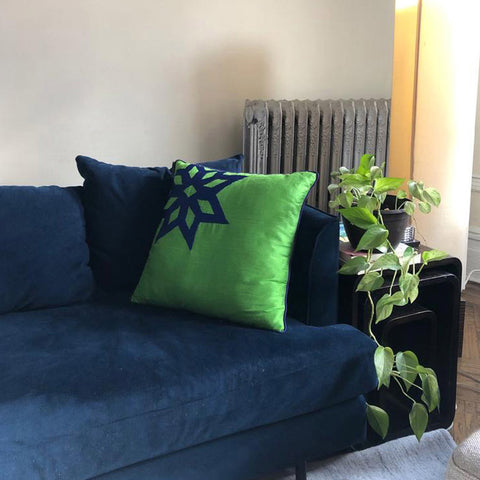 Lacivert kanepede yesil kare yastik ve yandaki sehpada cicek_Green square pillow on the navy blue sofa and flower on the side table