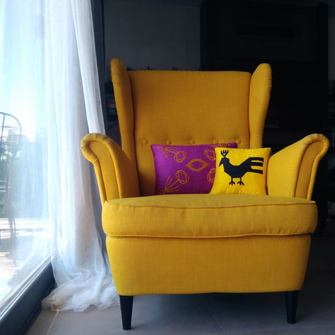 Sari berjer koltukta sari ve mor desenli yastiklar_Yellow and purple patterned pillows on the yellow wing chair