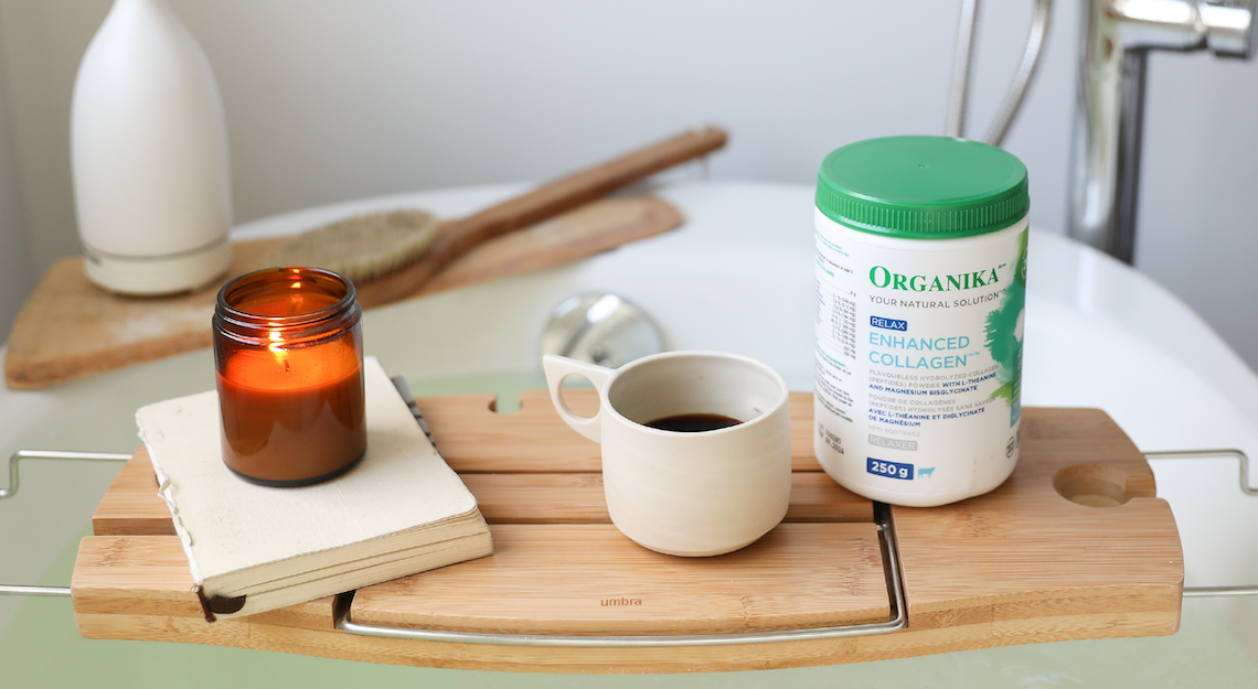 Organika's Enhanced Collagen Relax with a coffee and a candle beside a bath