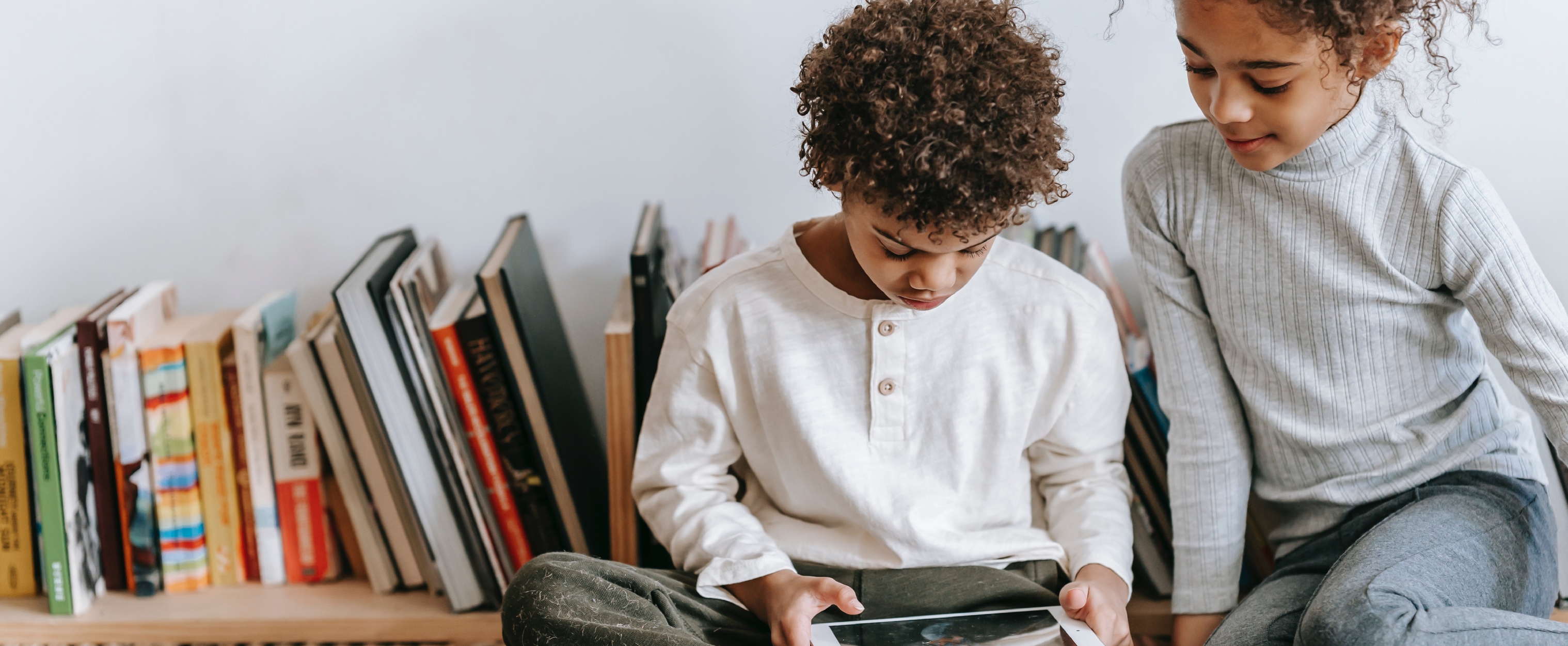 Two young children reading a book