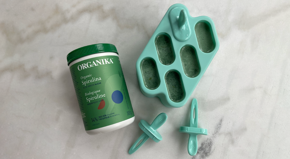 Organika's Spirulina Powder on a table beside Spirulina Protein Pops