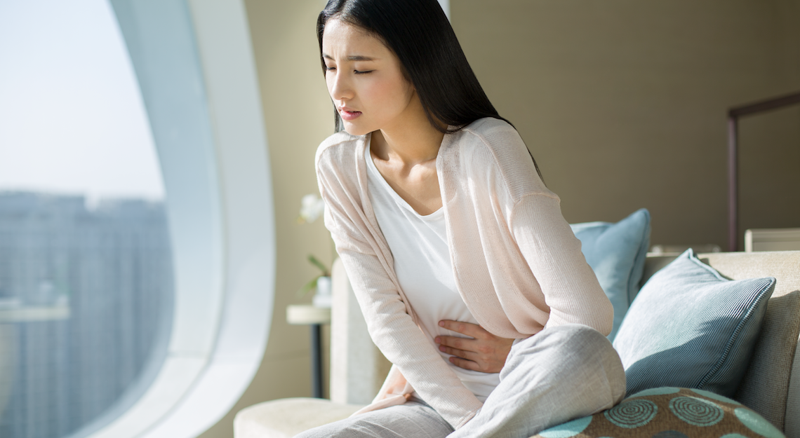 Woman holding her stomach because of stomach pain