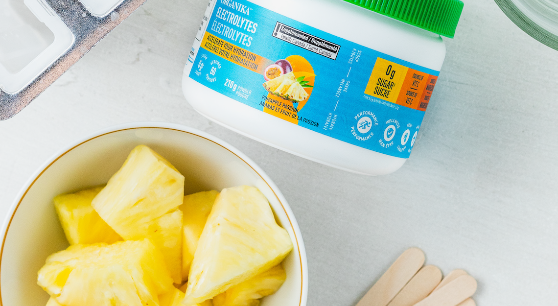 Organika's Electrolytes Pineapple Passion beside a bowl of pineapple