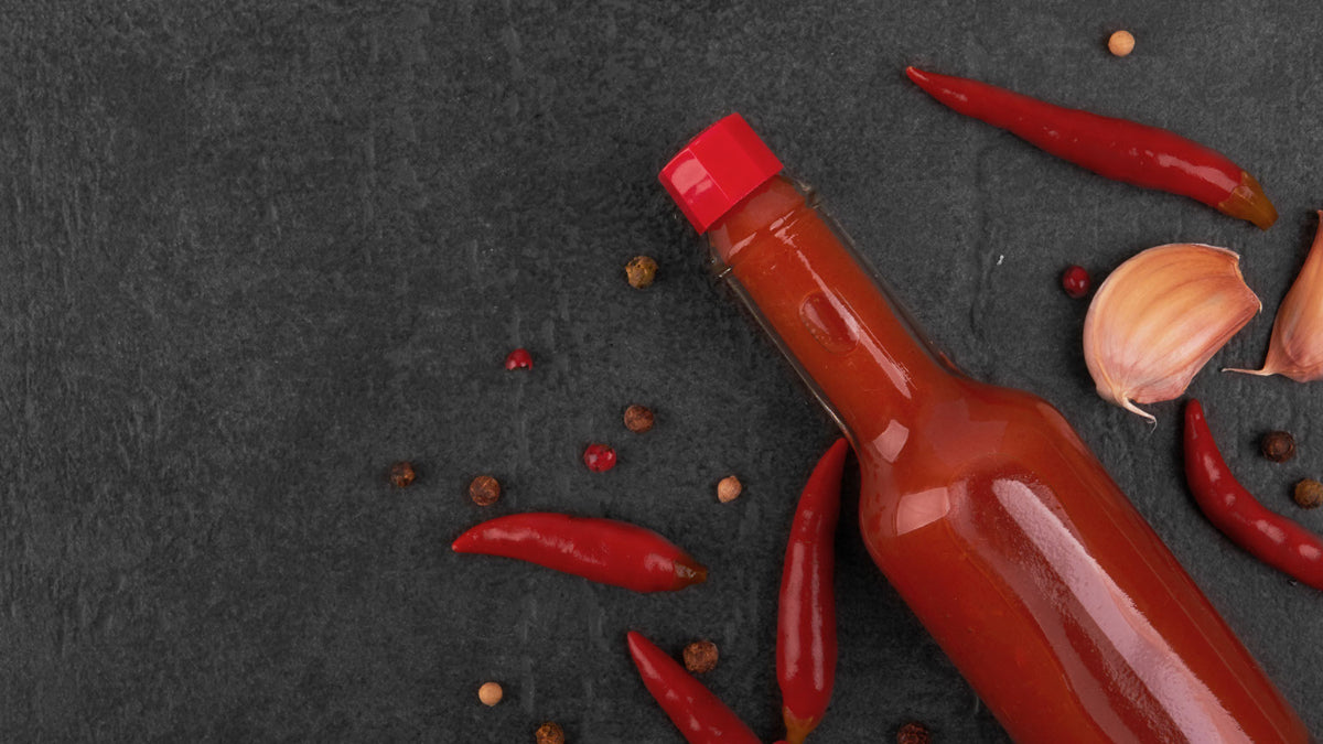 Hot sauce bottle with chili peppers and ingredients