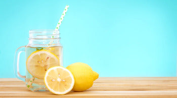 Lemons and a glass of lemonade on a table