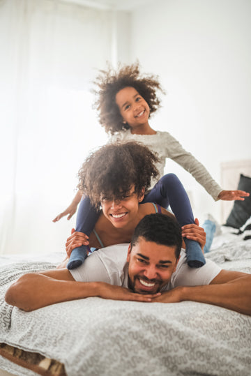 Family of three enjoying their bed