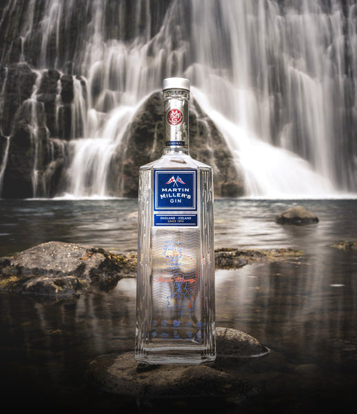 Martin Miller Gin bottle on a rock on the water with a majestic waterfall in the background
