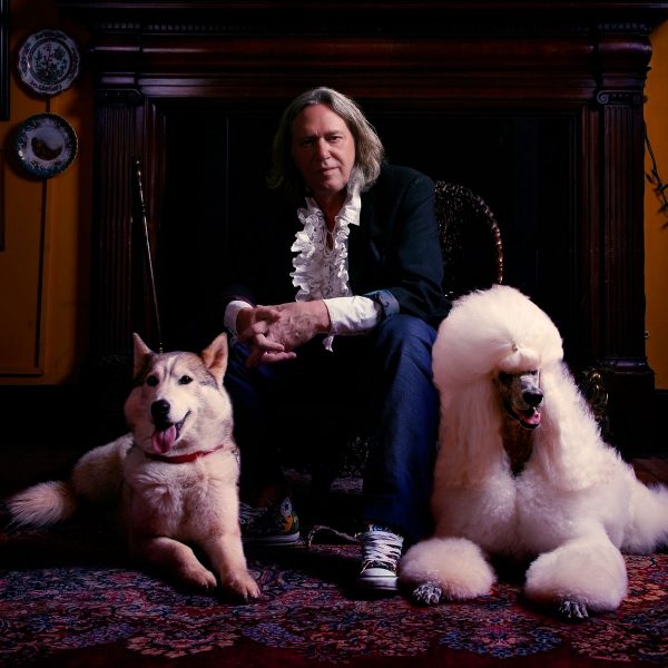 Martin Miller Gin founder and his two dogs sitting in front of a classic fireplace