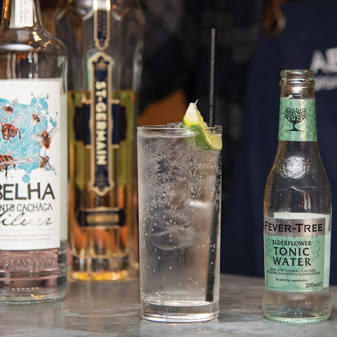 Abelha Cachaca spritz with a bottle of Fever-Tree edelflower tonic water and ice