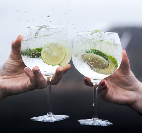 two glasses of Martin Miller gin tonic with lime cheering