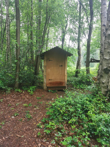 A slightly ramshackle looking hut in the middle of a forest. You can't tell but it is a compost toilet. 