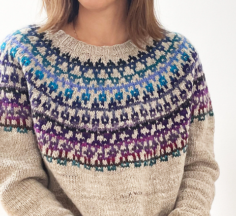 A fairisle yoked jumper, main colour beige and motif sort of bluey purple. 