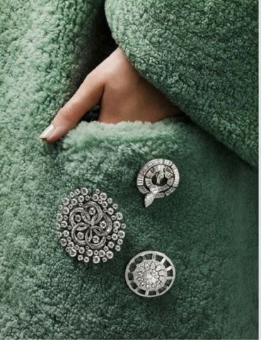 Multiple brooches on the coat pocket