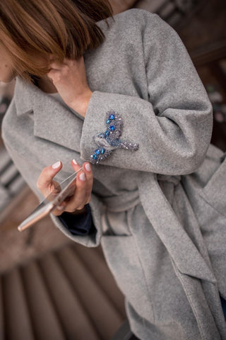 Bird brooch on the coat sleeve