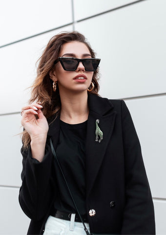 Woman wearing jade giraffe brooch and black jacket