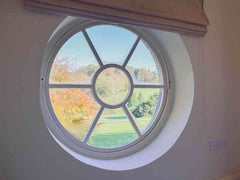 Circular window overlooking the Staunton Harold grounds, at the brewhouse apartment available to stay in Leicestershire 