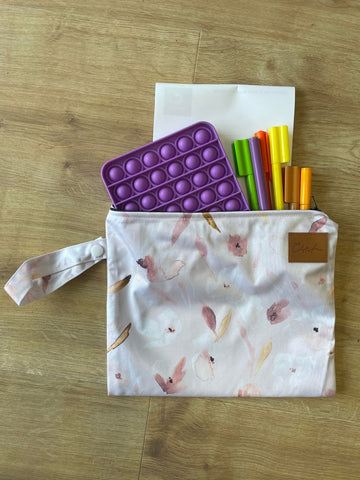 small pink wet bag with a purple pop it and textas