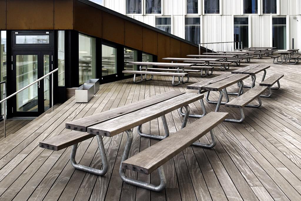 Mehrere Sitzbank-Tisch-Kombinationen aus Naturholz mit Stahlgestell